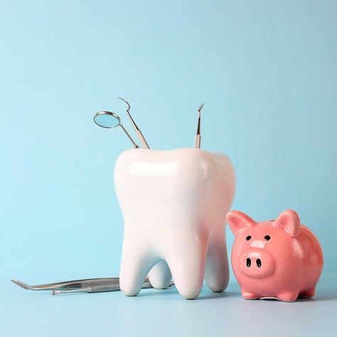 Rosa Sparschwein und Zahnmodell mit medizinischen Instrumenten auf blauem Hintergrund. Investition in die Zahngesundheit