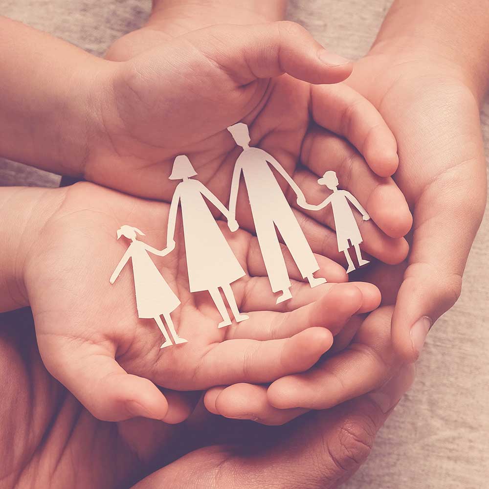 Hände halten Familienausschnitt aus Papier, Familienheim, Adoptionspflege, Obdachlosenunterstützung, psychische Gesundheit